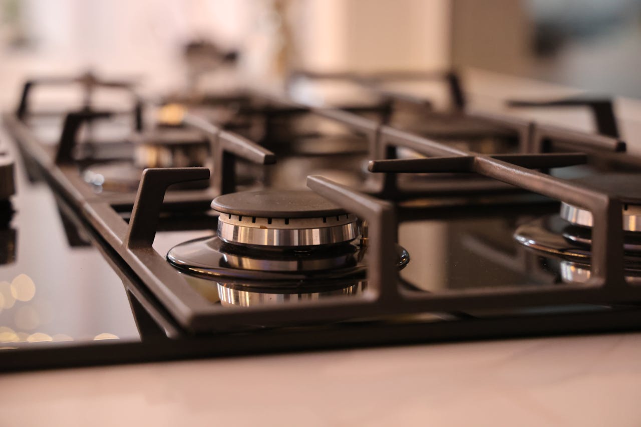 Home Close-up of a modern stainless steel gas stove top, ideal for contemporary kitchens and cooking environments.